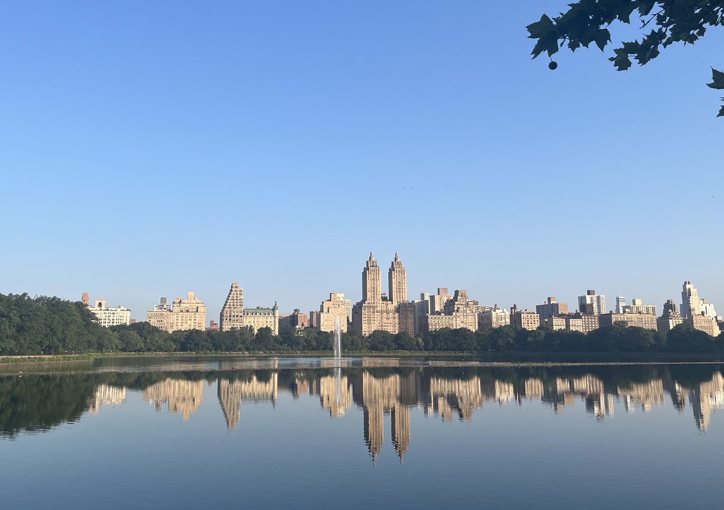 Panorama dello skilyne dell’Upper West Side riflesso sul lago di Central Park in una limpida mattina estiva.