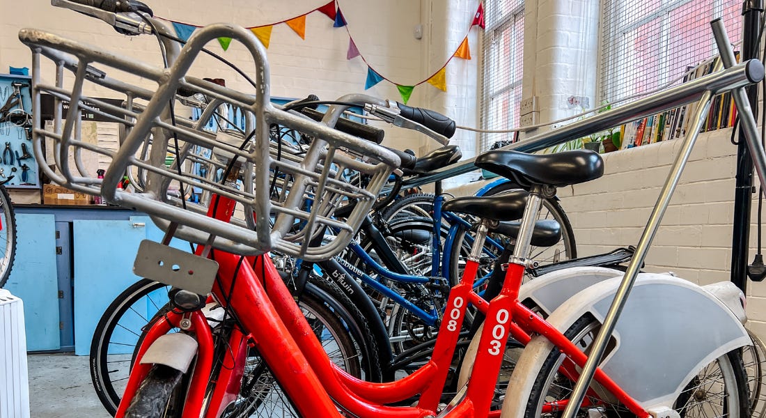 A close-up of a parked red bike in a garage with blue cabinets and rainbow bunting behind it A close-up of a parked red bike in a garage with blue cabinets and rainbow bunting behind it