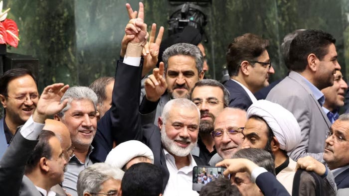 Ismail Haniyeh flashes a victory sign at the Iranian parliament in Tehran on Tuesday