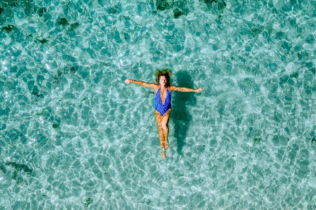 woman wearing blue one-piece bikini on the body of water woman wearing blue one-piece bikini on the body of water