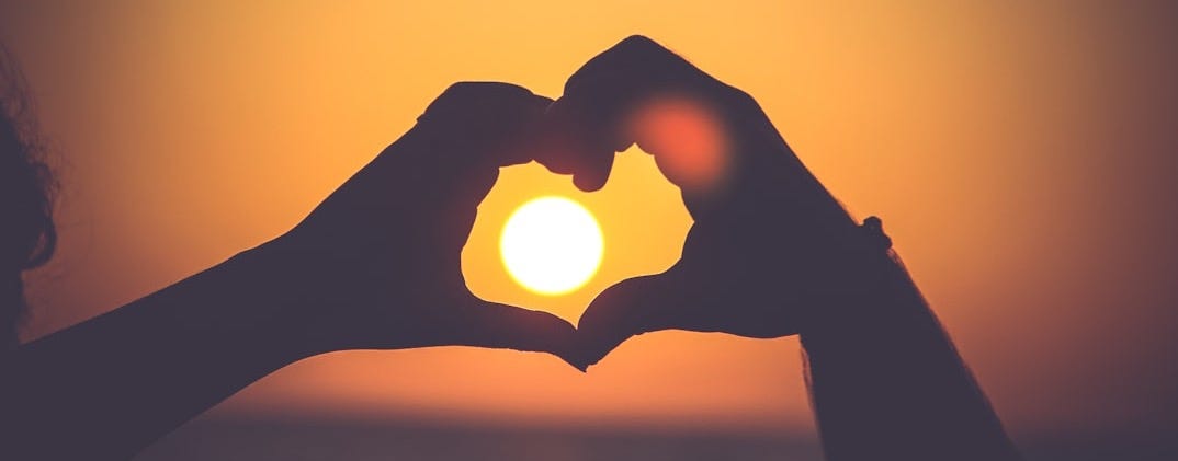 silhouette of person's hands forming heart