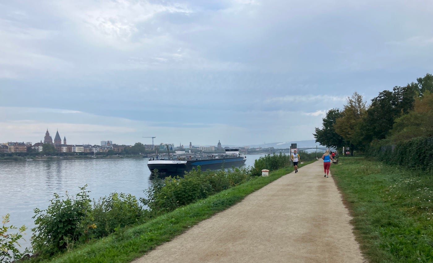 A wide beige gravelled path by the river