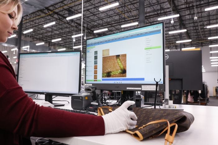 A worker using a microscope camera to verify the authenticity of a Louis Vuitton handbag.