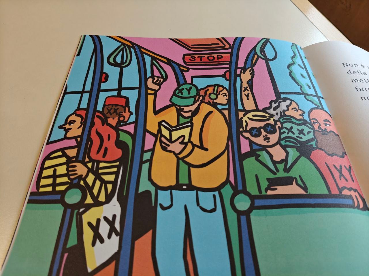 Illustrazione colorata in stile fumetto che mostra un gruppo di persone in piedi all'interno di un autobus affollato. I personaggi hanno colori vivaci e un design audace: un uomo al centro con un cappellino verde con le lettere "X Y" legge un libro. Molti personaggi indossano abiti o cappelli che riportano le lettere "X Y" o "X X". Il cartello "STOP" è visibile in alto al centro.