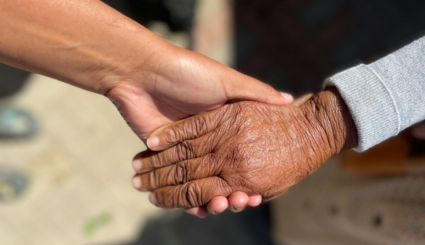 a close up of two people holding hands