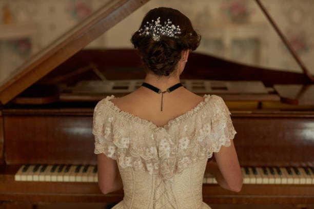 Lady Grand Piano in Elegant Interior Back view of classic young lady wearing lace dress with pearls in hair playing grand piano in elegant interior, copy space victorian women stock pictures, royalty-free photos & images Lady Grand Piano in Elegant Interior Back view of classic young lady wearing lace dress with pearls in hair playing grand piano in elegant interior, copy space victorian women stock pictures, royalty-free photos & images