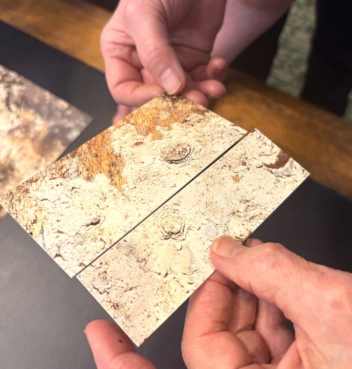 Diptych: Three images on a wall in a gallery; Two hands hold two pieces of paper to see if it's a 'match.' 