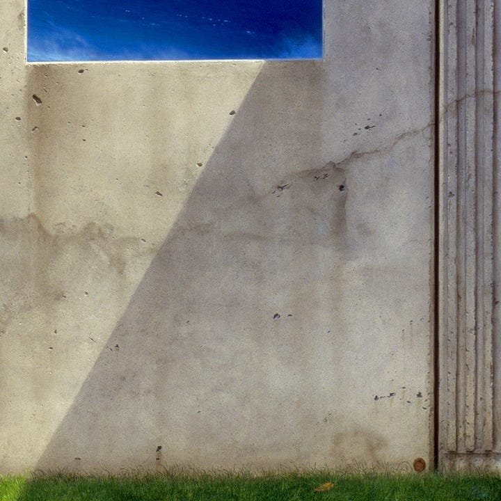 LEFT: Detail from THE INEXORABLE EQUATION featuring a view of the crashing wave framed by the stone facade. The water is a soothing blue darker at its depths and lightening as it climbs to a thin frothing crest. At the base of the wave, the water mists.  RIGHT: Detail from THE INEXORABLE EQUATION featuring shadow cutting a diagonal across the smooth concrete surface. The stone is weathered as indicated by wash lines. At its base, there is a hint of green grass. In the lower right, the artist’s sigil, the stylized letters M and W combined within a circle, is presented as if on a token or coppery wax smushed against the surface.