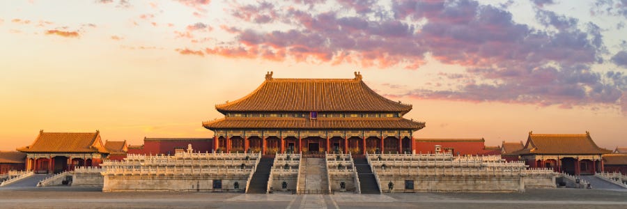 The Forbidden City in Beijing at sunset, its golden-roofed Hall of Supreme Harmony rising above wide marble staircases and terraces.