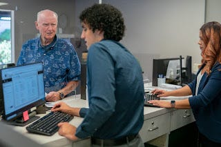 Bank Tellers Serving Elderly Male Customer
