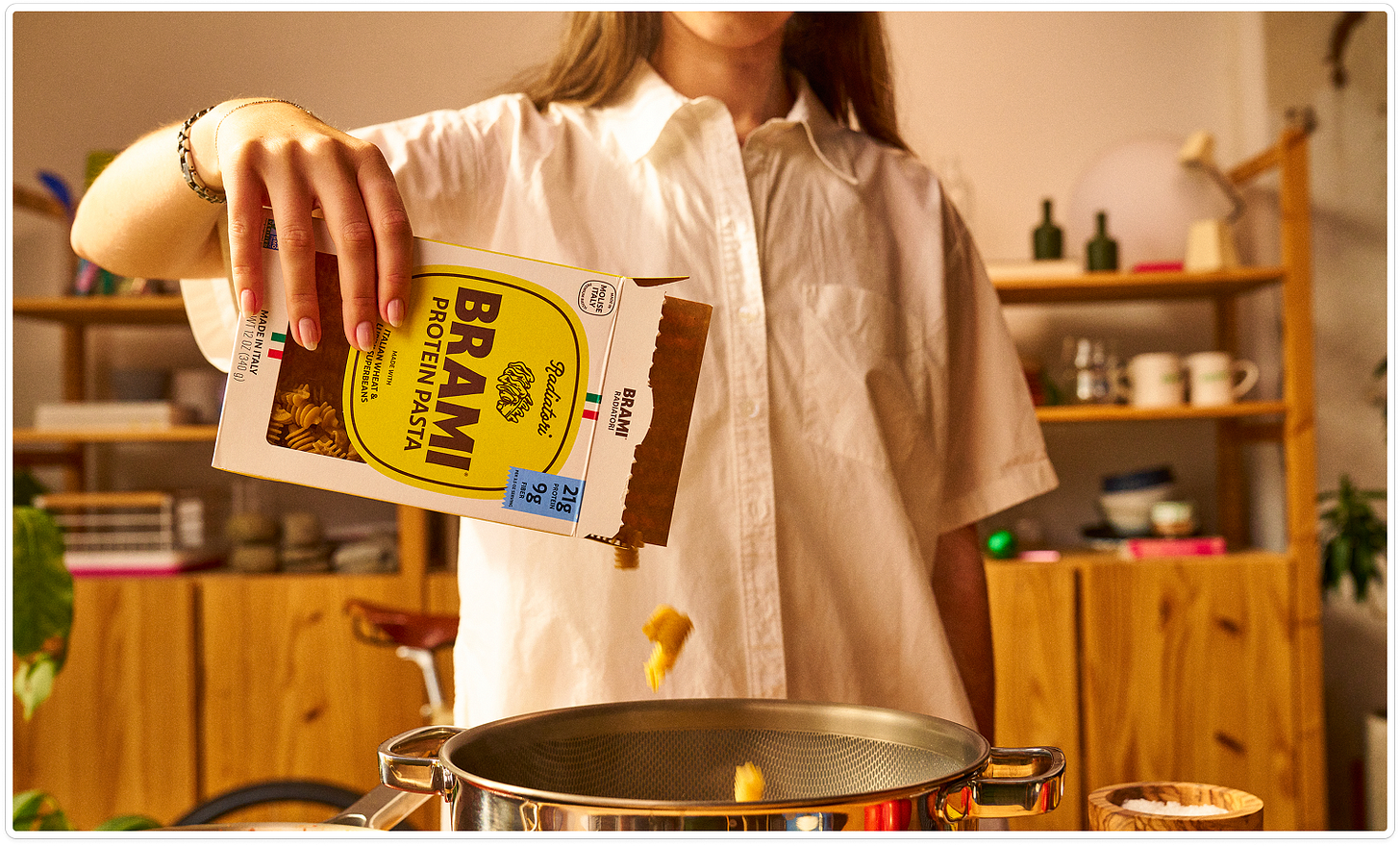 Pouring Brami protein pasta into a pasta pot. Pouring Brami protein pasta into a pasta pot.