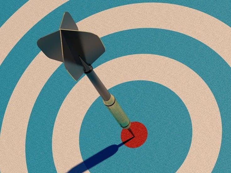 This may contain: an arrow hitting in the center of a bulls eye target with a shadow on it