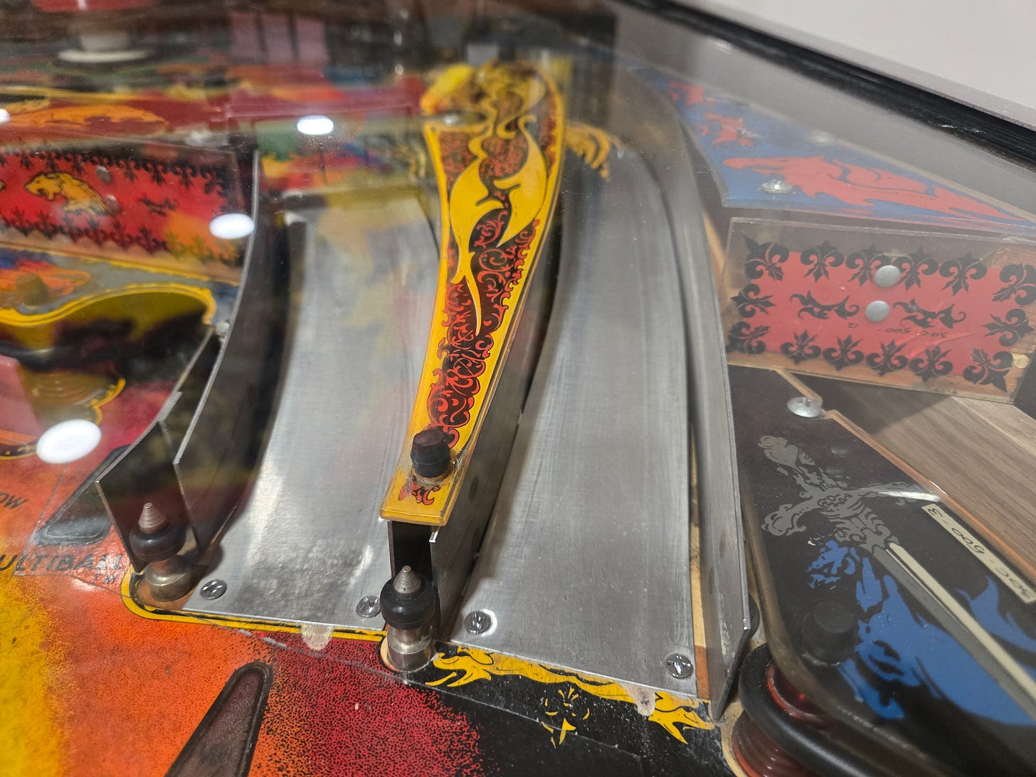 Close-up of the Black Knight (1980) playfield showing the ramp structure and shooter lane with golden dragon artwork on the plunger housing Close-up of the Black Knight (1980) playfield showing the ramp structure and shooter lane with golden dragon artwork on the plunger housing