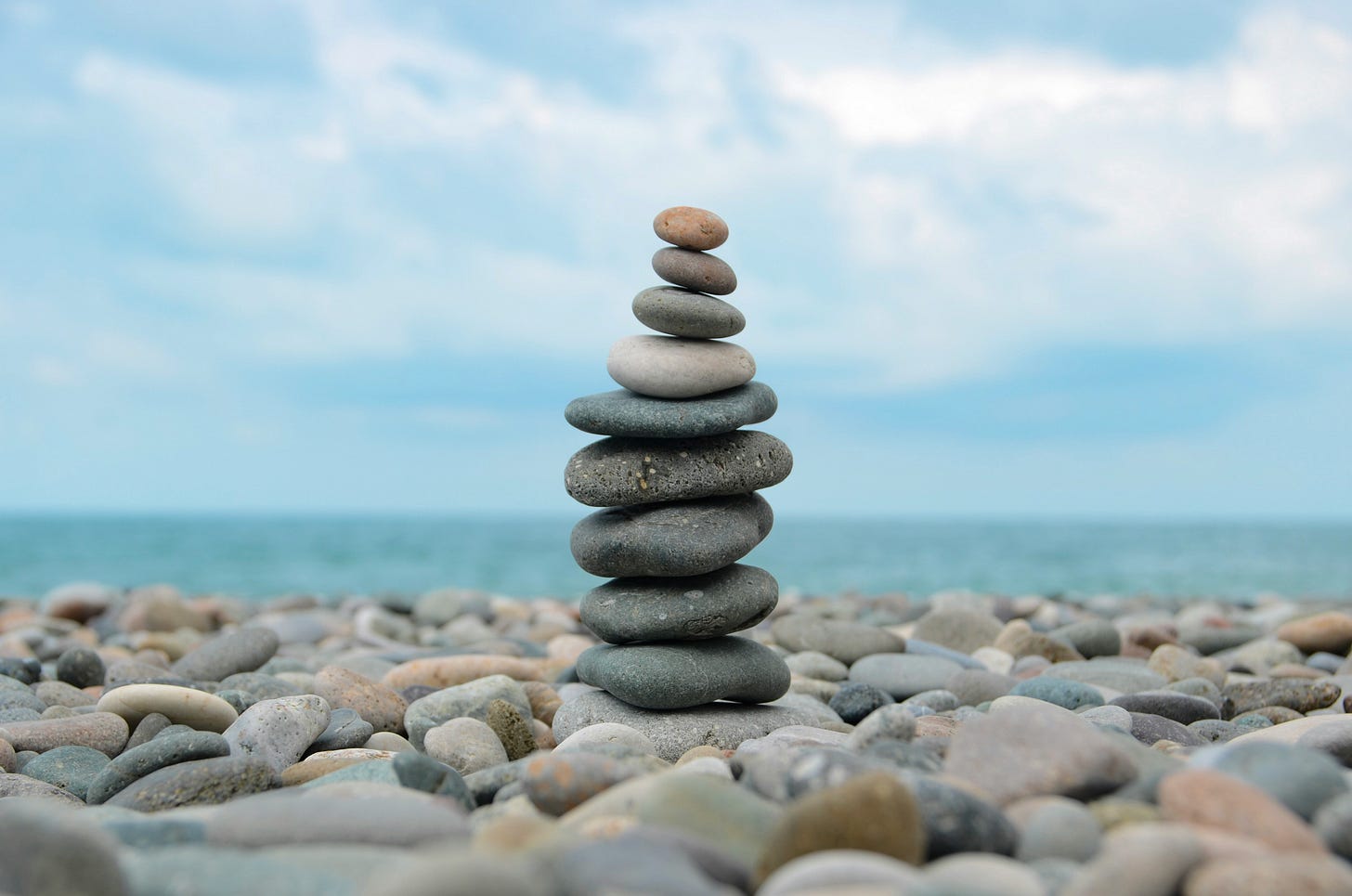 pebbles on a beach with a stack of pebbles in the centre