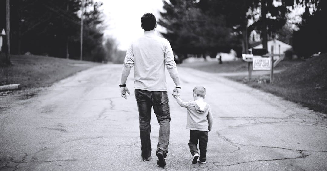 man holding baby's hand