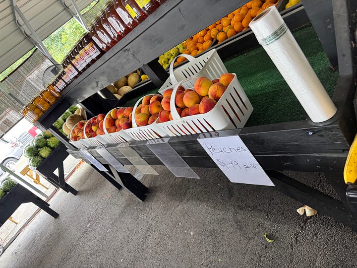 peach displays at a farmstand and the grocery store
