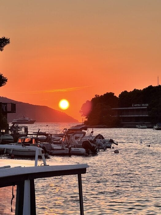 Stunning orange sunset over marina with boats and Hotel Helios Croatia Stunning orange sunset over marina with boats and Hotel Helios Croatia
