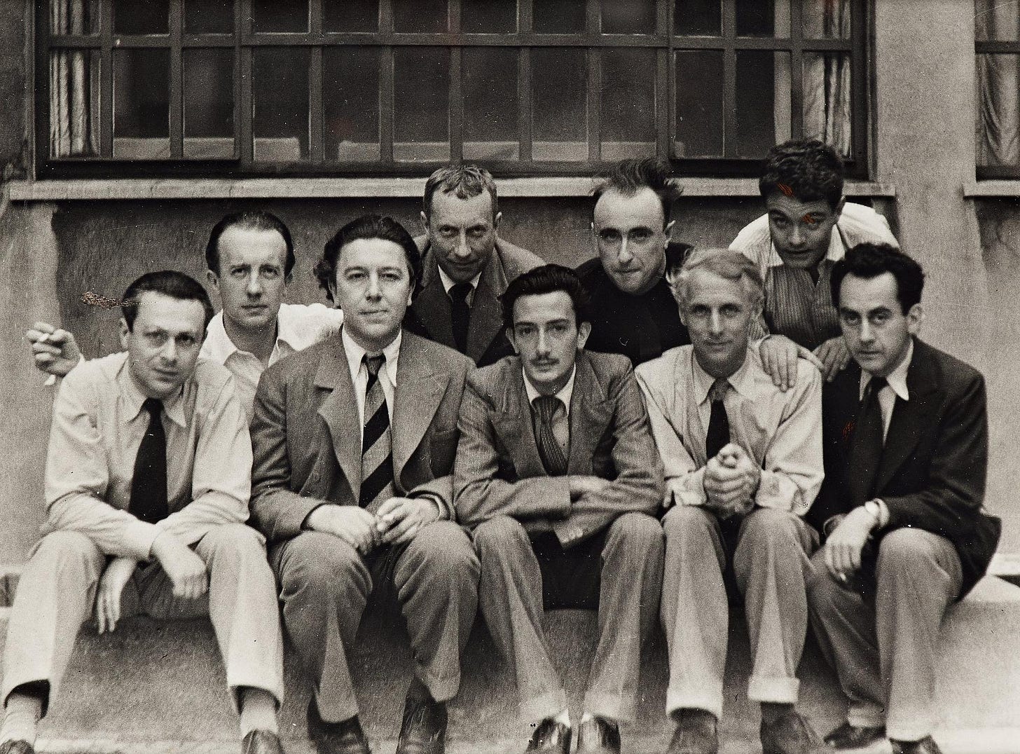 The Surrealist group around 1930. Top row: Paul Éluard, Hans Arp, Yves Tanguy, René Crevel. Bottom row: Tristan Tzara, André Breton, Salvador Dalí, Max Ernst, Man Ray