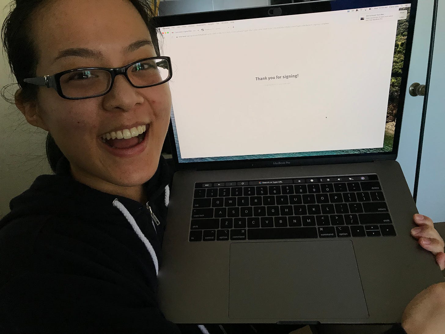 Me holding my laptop up after signing my offer letter for Figma.