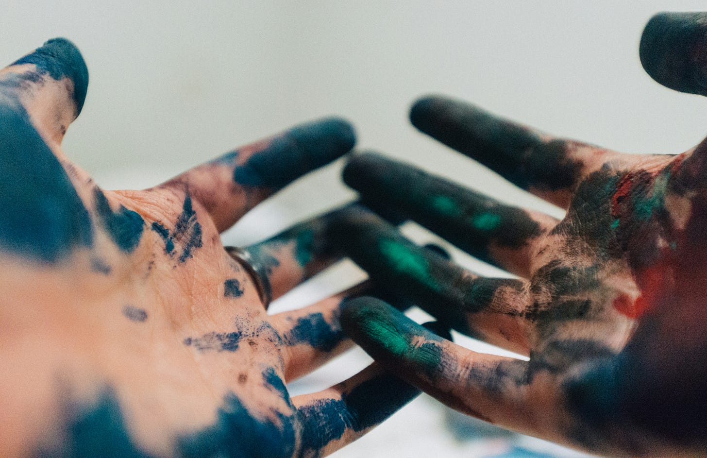 A pair of hands covered in colored paint