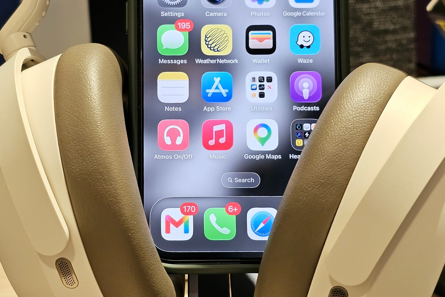A photo of an Apple iPhone 16 with a custom "Atmos On/Off" icon on the bottom-left corner of the home screen. A photo of an Apple iPhone 16 with a custom "Atmos On/Off" icon on the bottom-left corner of the home screen.