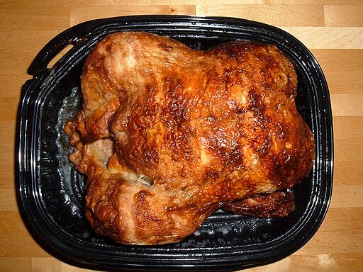 Wikimedia image of a store-bought rotisserie chicken sitting in a black plastic container. BrokenSphere, CC BY-SA 3.0 <https://creativecommons.org/licenses/by-sa/3.0>, via Wikimedia Commons
