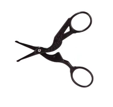 Two pairs of scissors shaped like cranes: one black with blunt tips, and one gold and sharp