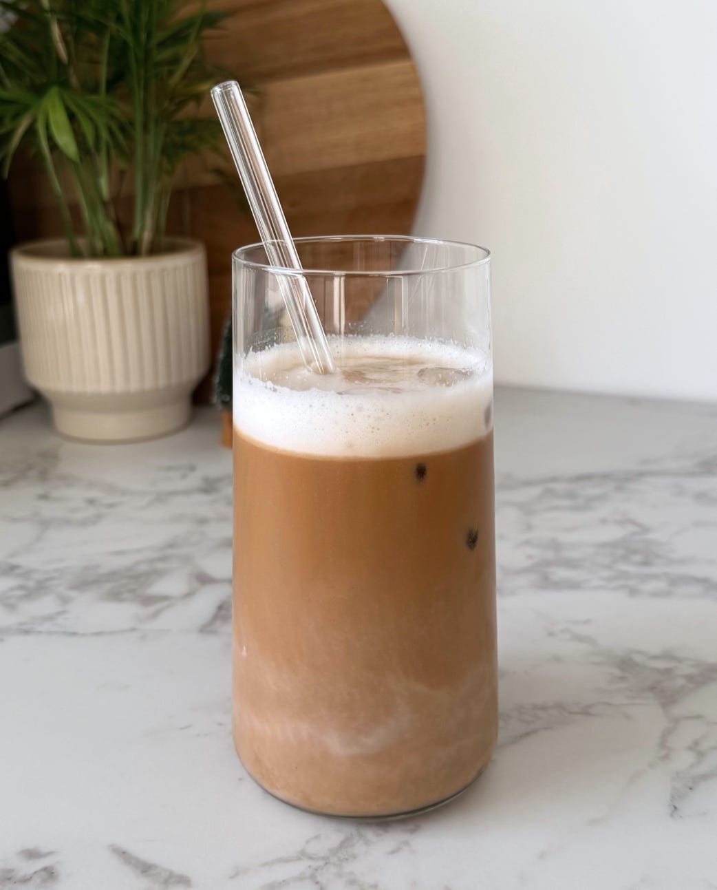Iced speculoos latte in a glass with a creamy almond milk layer, ice cubes, and a sprinkle of speculoos spice on top. Iced speculoos latte in a glass with a creamy almond milk layer, ice cubes, and a sprinkle of speculoos spice on top.
