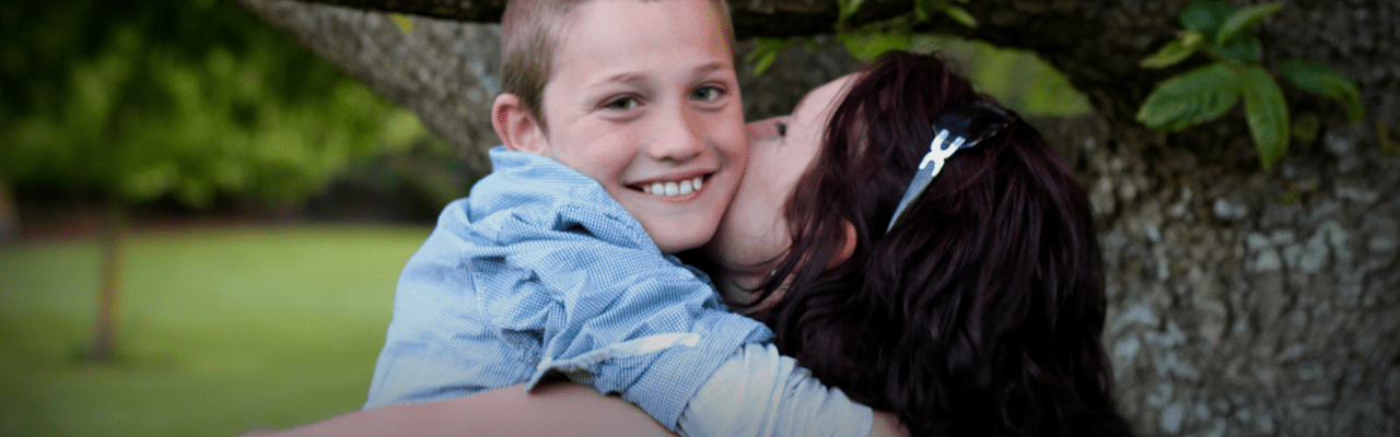photo of two siblings outside, one is carrying the other