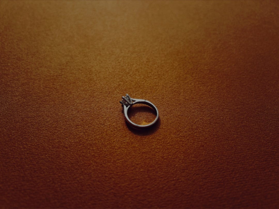 a silver ring sitting on top of a brown surface