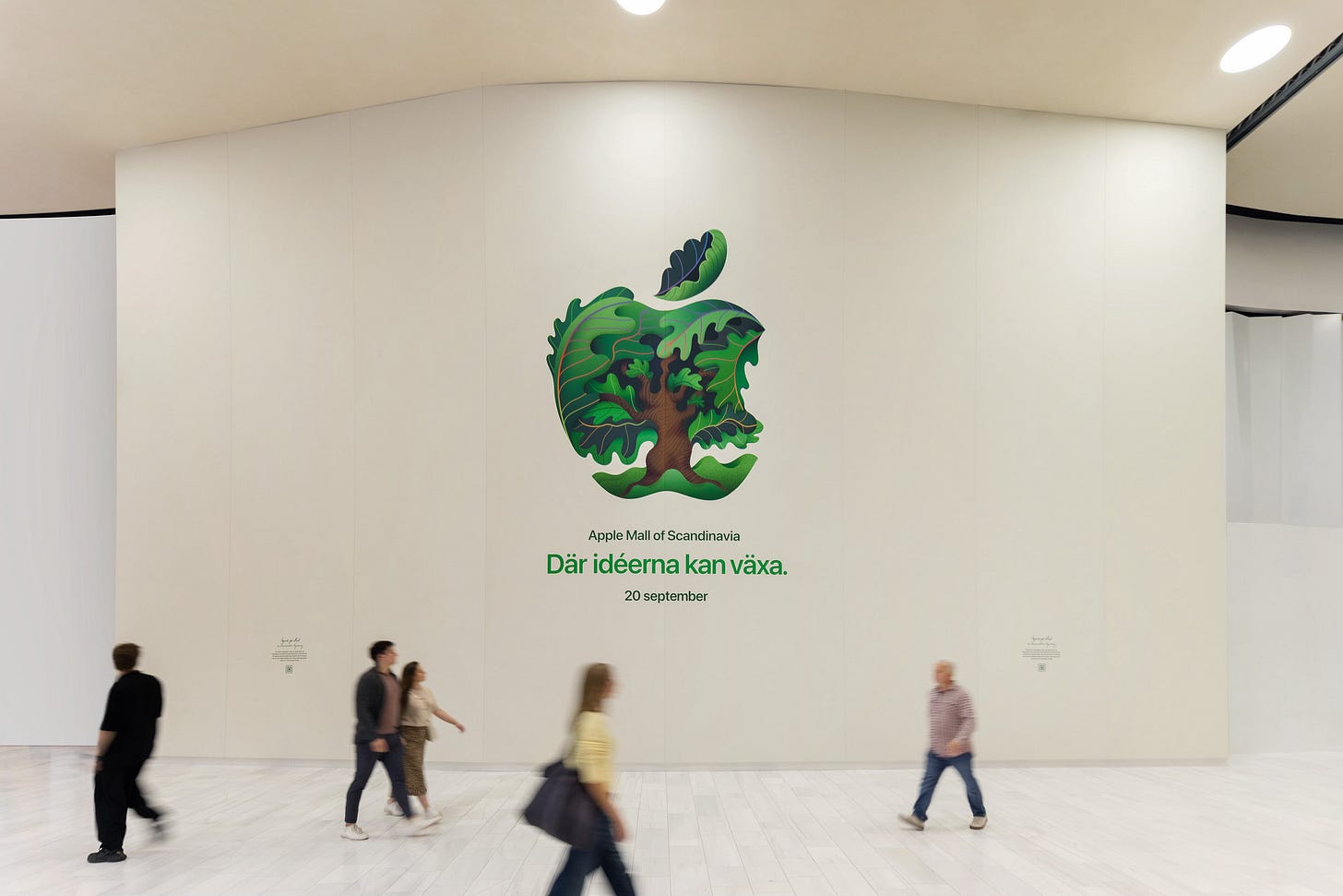 Apple Mall of Scandinavia covered by an artful barricade with an illustrated Apple logo. People are walking past the store. Apple Mall of Scandinavia covered by an artful barricade with an illustrated Apple logo. People are walking past the store.
