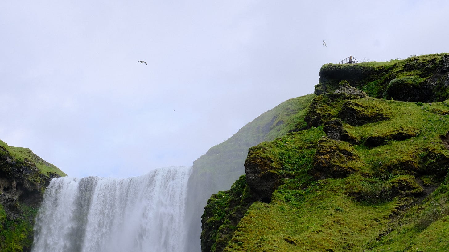 A waterfall with a waterfall in the background

AI-generated content may be incorrect.