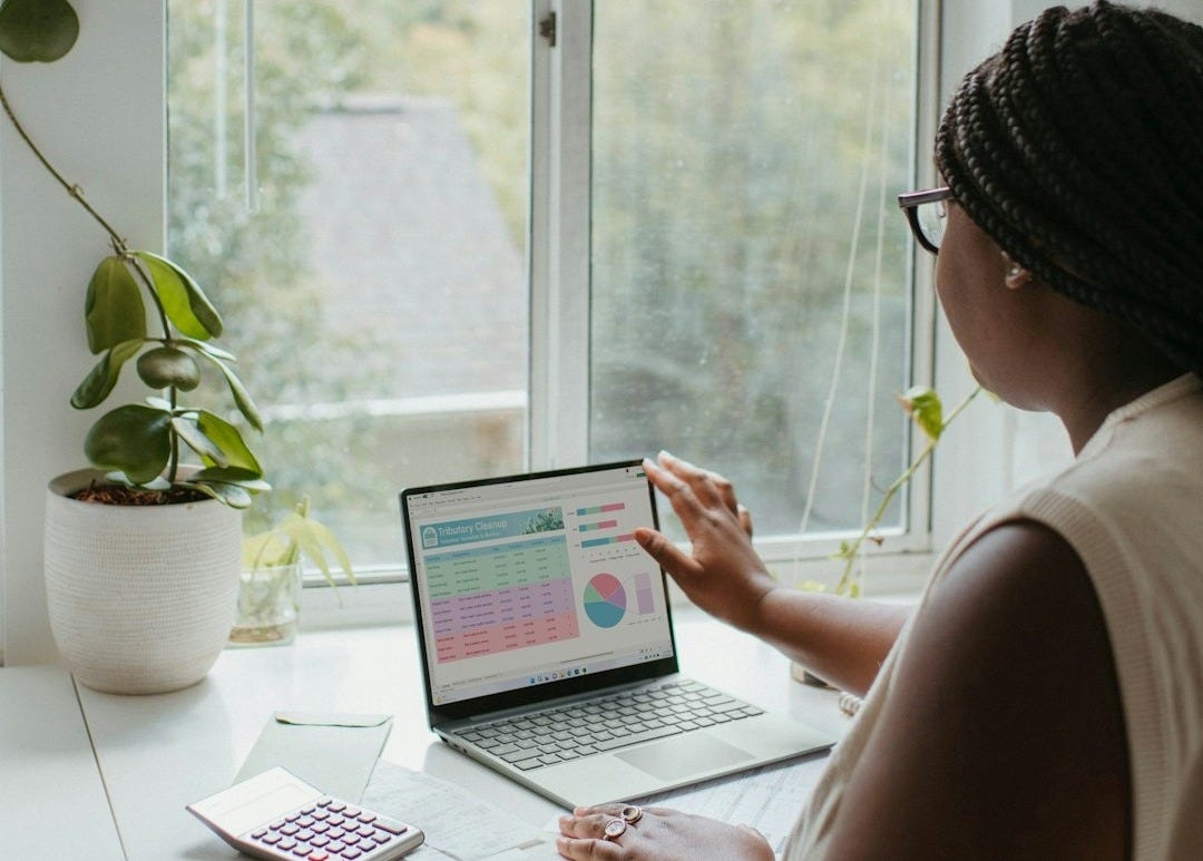 a woman sitting at a table using a laptop computer