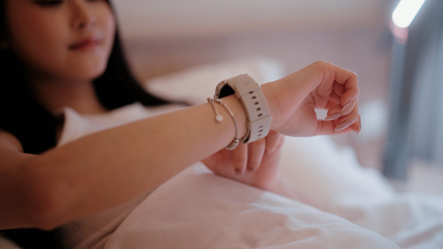 Woman checking smartwatch in bed. Woman checking smartwatch in bed.