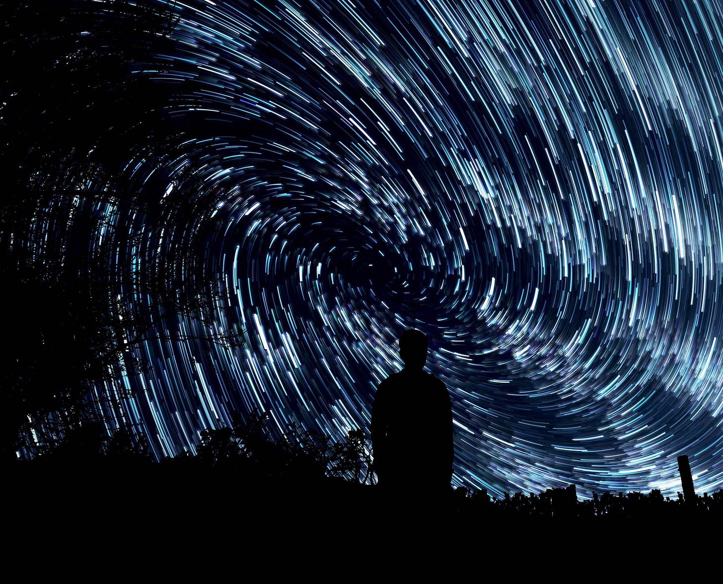 A vast swirling dark blue and white sky fills the image, with the silouette of a single person at the bottom center