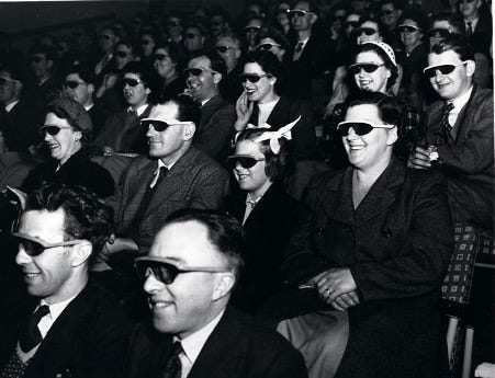 Audience sitting in a cinema wearing 3d glasses Audience sitting in a cinema wearing 3d glasses
