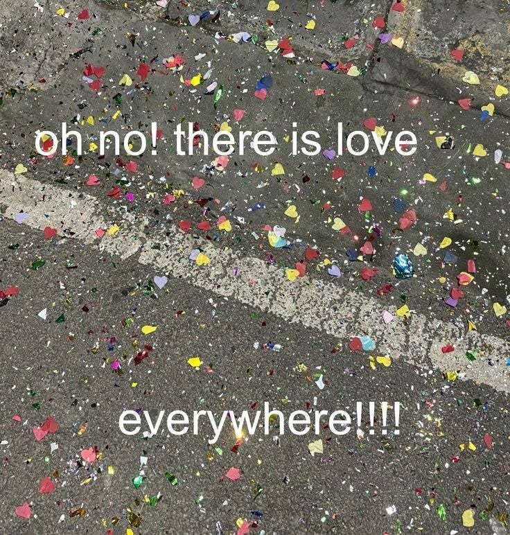 This may contain: there is confetti all over the street and on the ground with words that read, oh no there is love everywhere