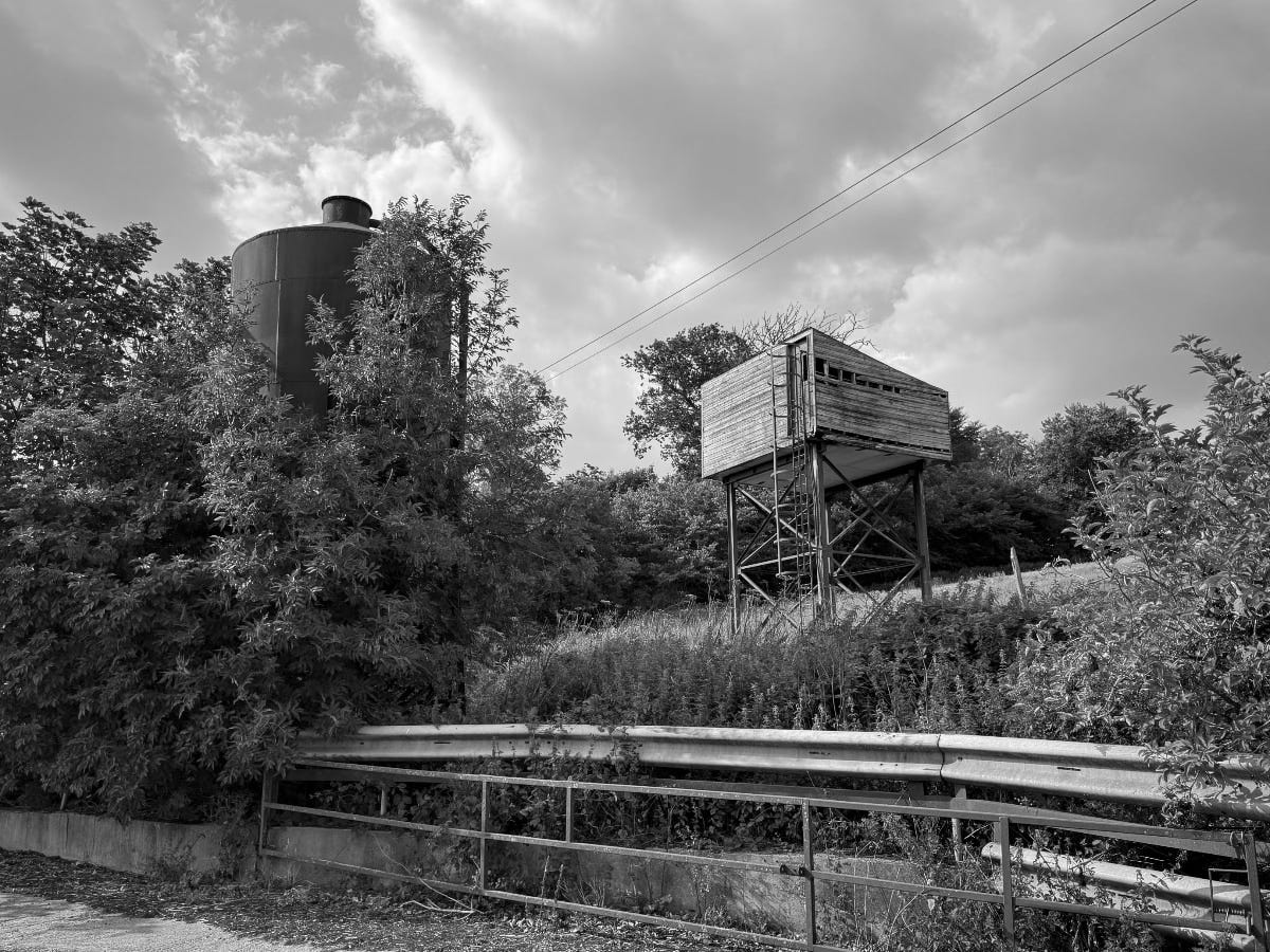 A wooden box-type structure sits on stilts next to a silo. No idea what it is for. Perhaps it's a crude water tower. Either way, it looks cool.