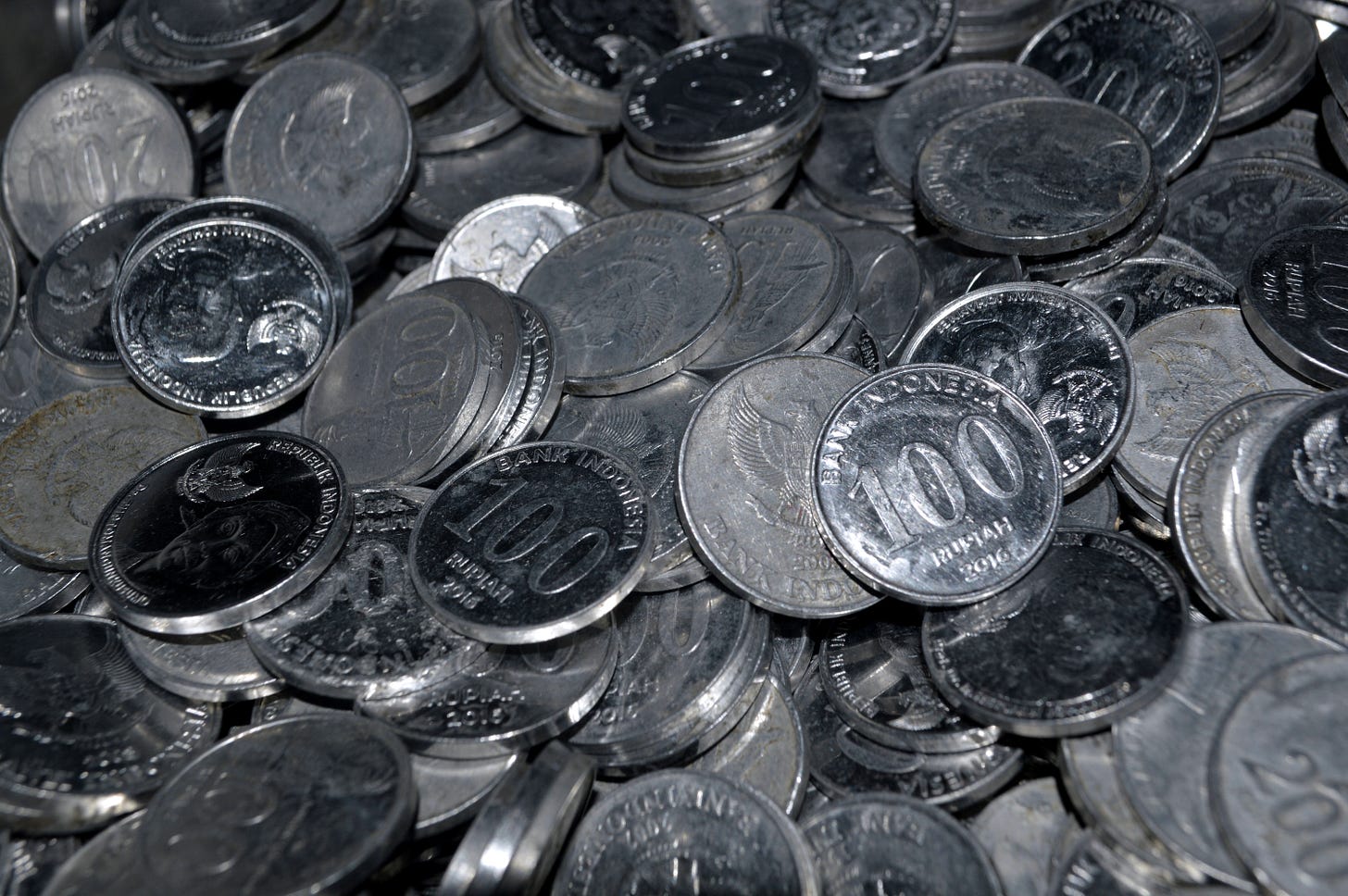 A close-up of an Indonesian Rupiah coin, symbolizing the day-to-day purchasing power that is currently feeling the squeeze of imported inflation and rising energy costs.