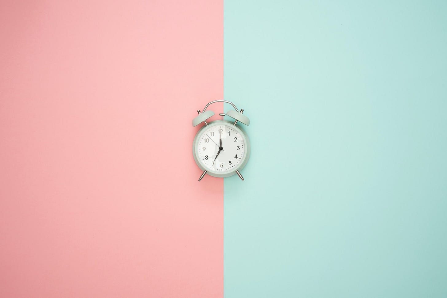 White clock in the centre of a pink and blue backdrop