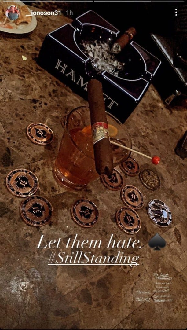Instagram post of SAPD challenge coins i front of an ashtray with a cigar in it and the Instagram caption Let them hate. #StillStanding