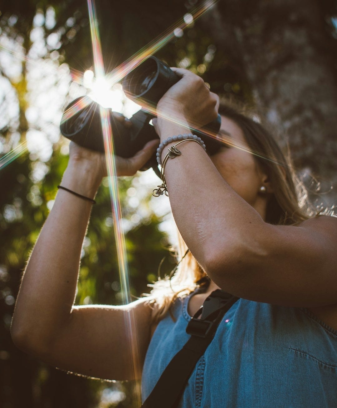 woman using binoculars in forest