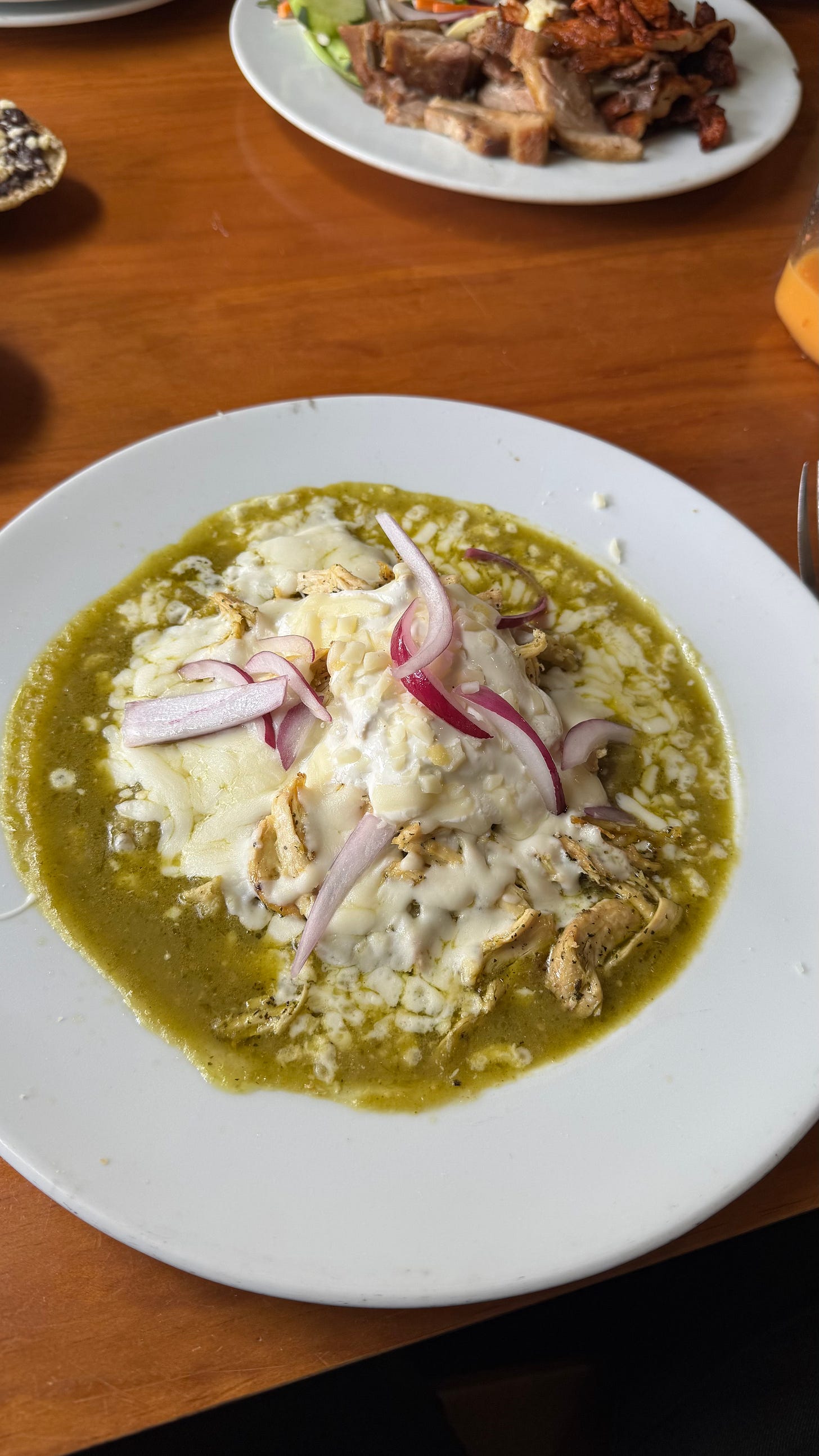 Green enchiladas on a white plate.