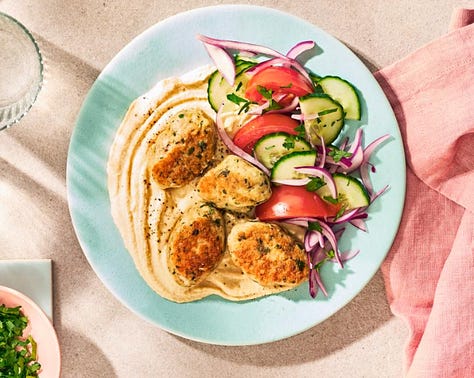 9 different plates of hummus with varying toppings from meatballs to lentils