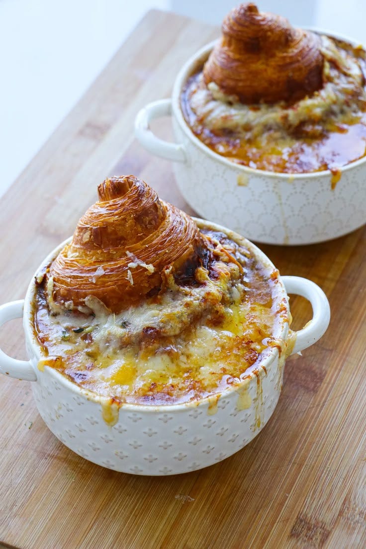 This may contain: two white casserole dishes sitting on top of a wooden cutting board