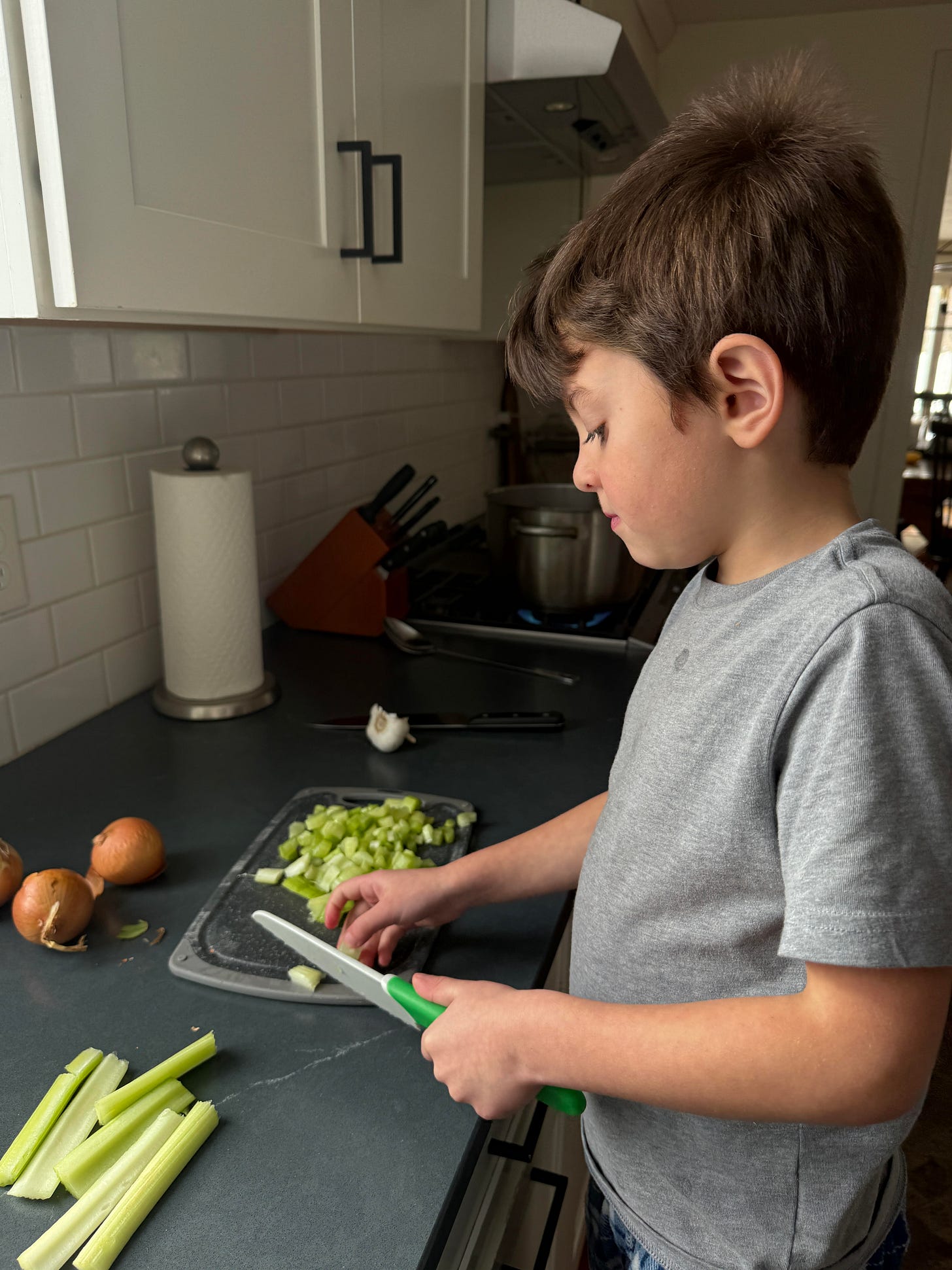 One of Alina’s son’s in the kitchen cutting celery