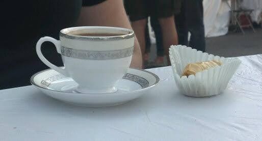 Photo of a cup of Greek coffee in a china tea cup and saucer next to a Greek pastry