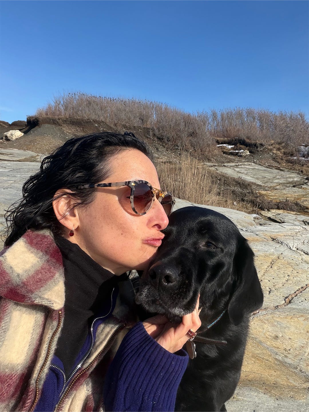 Dr Catherine with her black lab on a rocky beach Dr Catherine with her black lab on a rocky beach