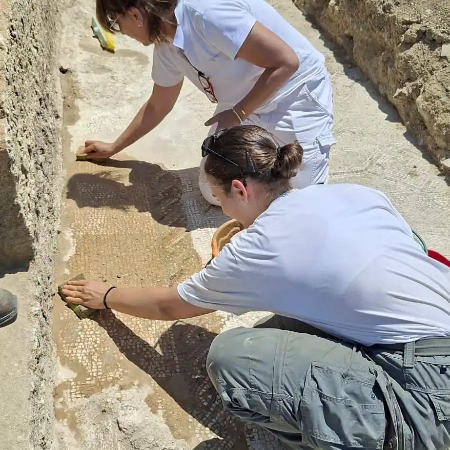 **Archaeologists cleaning the newly discovered mosaic at the excavation site. Credit: Parco Archeologico e Paesaggistico della Valle dei Templi**