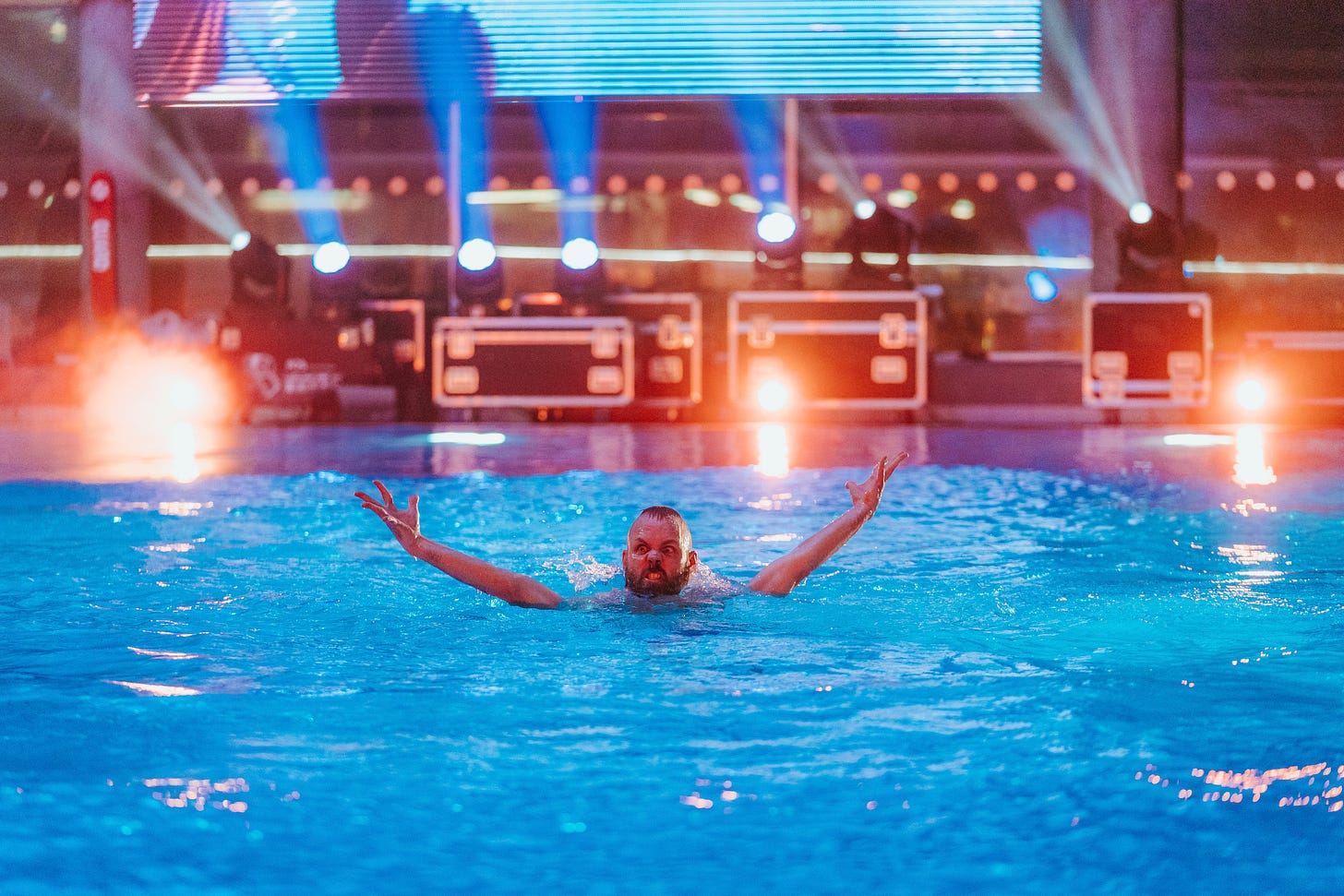 Døds Battle of the Tower competitor celebrates in a pool surrounded by event lighting.